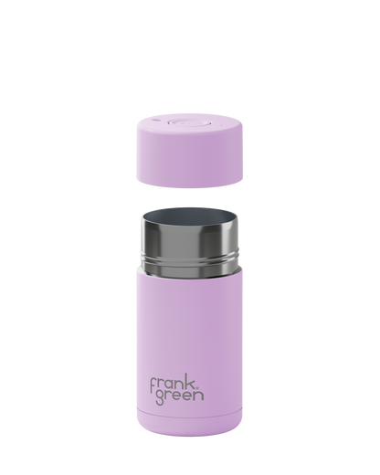 A light purple insulated bottle with its cap removed and floating above the base, showing a stainless steel rim. The bottle features the 'frank green' logo near the bottom and is set against a plain white background.